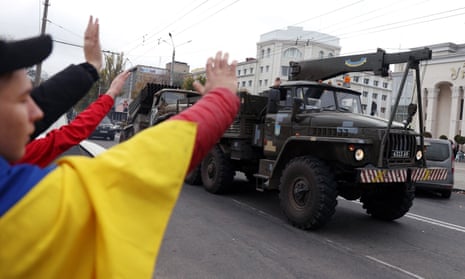 Local residents cheer and wave at Ukrainian military vehicles driving past as they celebrate the liberation of their town in Kherson, on November 13, 2022. (Photo by AFP) (Photo by -/AFP via Getty Images)