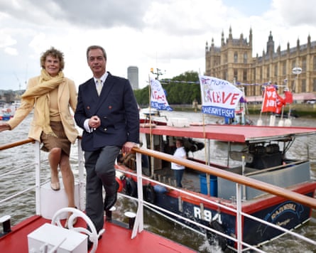 Hoey and Farage sit on the edge of the boat on the Thames next to a smaller boat with leave flags.