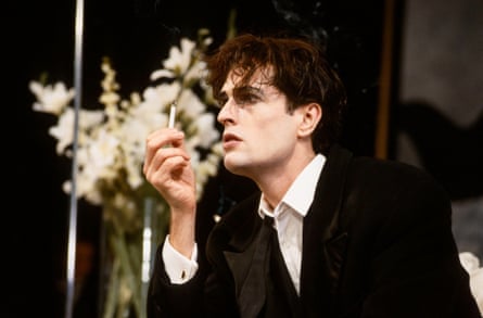 Heavily made up, Everett smokes a cigarette on stage