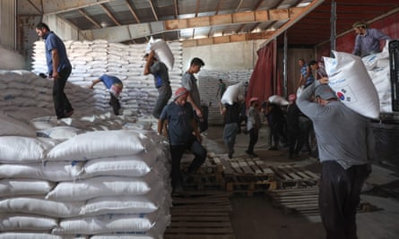 Workers unload bags of aid at a warehouse near the Syrian Bab al-Hawa border crossing with Turkey, on 10 July 2023.