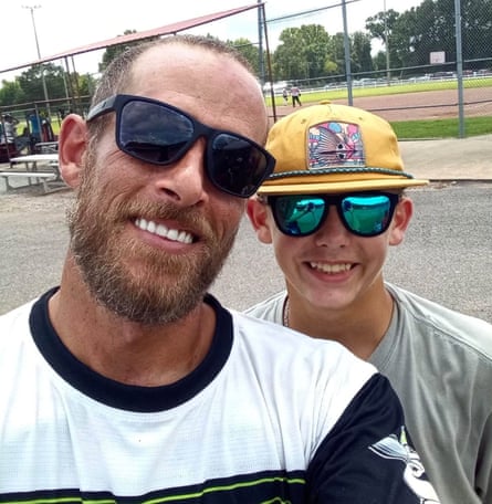 Casey Sparks and his son Cason, both in sunglasses, smile together near a baseball field