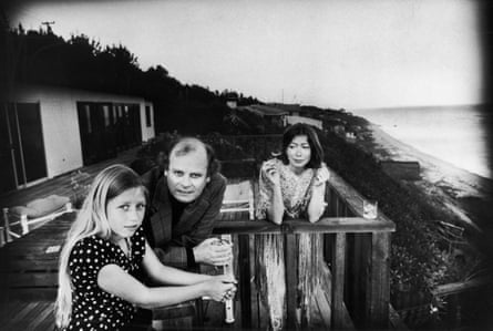 didion smokes on porch next to man and girl