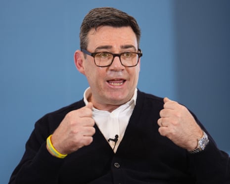 Andy Burnham gestures with both fists raised while speaking