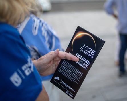 A woman holds a leaflet promoting the 2026 total solar eclipse in Spain, which is set to pass over Madrid.