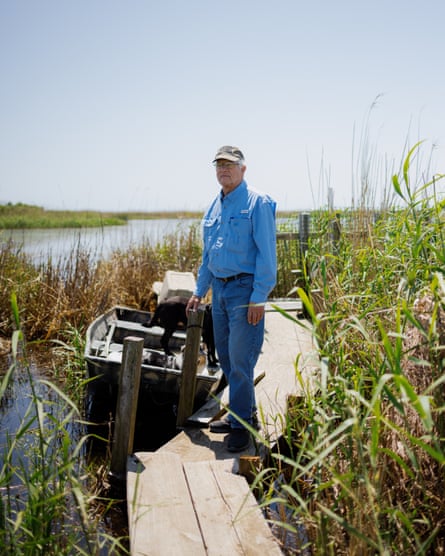 a man stands outside on a dock in a bayou