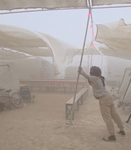 A man holding up a pole in a festival tent