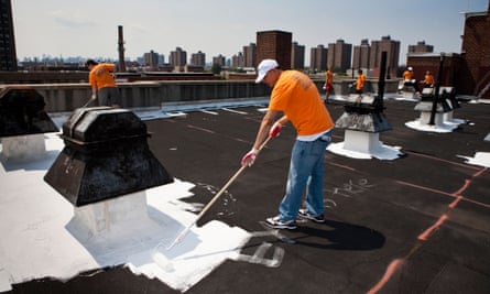 Volunteers paint a New York rooftop with specialised coating material that has a high solar reflectivity.