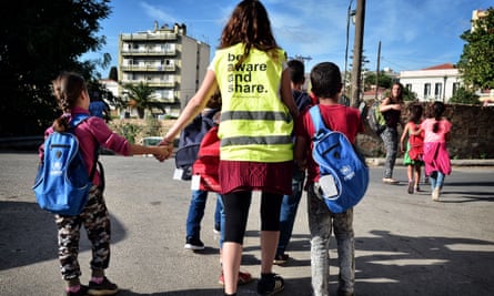Volunteers walk a group of refugee children towards their school on the island of Chios.