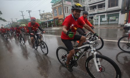 Supporters of Aung San Suu Kyi promote the NLD party as monsoon rains continue.