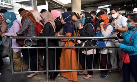 People wearing face masks, amid the Covid-19 coronavirus outbreak, commute at Tanah Abang train station in Jakarta.