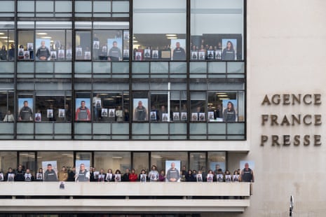 Agence France Presse employees pose on the balconies and in front of windows of the agency’s headquarters in Paris.
