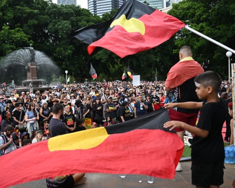 A large crowd gathers and waves the Australian Aboriginal flag during an Invasion Day protest in Hyde Park in Sydney on 26 January 2026