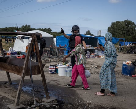 A police officer pointing as two women walk past