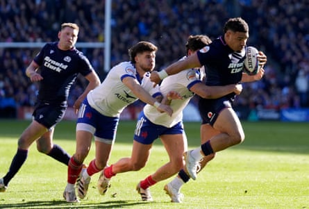 Scotland captain Sione Tuipulotu tries to break through the France defence as Finn Russell looks on.