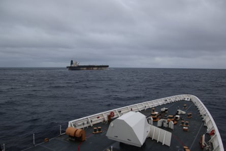 The bow of a vessel in the foreground and an oil tanker in the distance