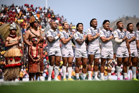 Samoa rugby league players stand for the national anthem beside traditional costumed performers
