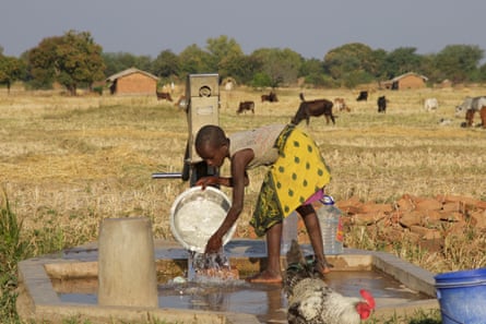 A girl washes dishes at a borehole near Eland coal mine in Mwabulambo, Karonga district