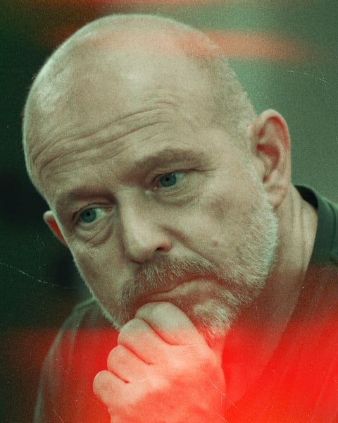 Man tilts his head and looks away as his hand holds his chin