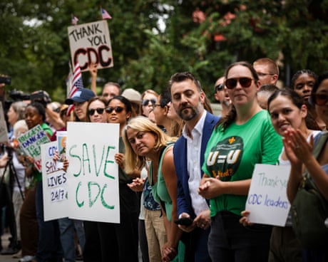 People hold signs in support of the CDC.