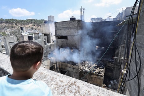 A Palestinian looks at smoke billowing from a house targeted by Israeli forces during a raid on the Nur Shams camp for Palestinian refugees, east of Tulkarm in the occupied West Bank, on 1 July.