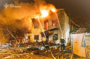 Firefighters attempt to extinguish a fire in a two-storey building after a Russian attack in Kharkia