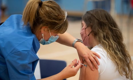 A nurse vaccinates a woman for the UK Covid-19 vaccination programme