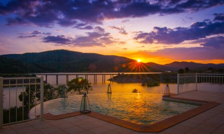 An infinity pool overlooking the huge river at sunset.