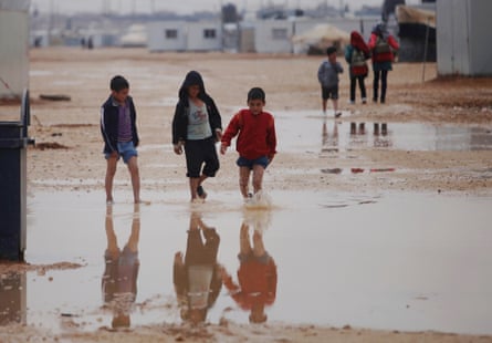 Syrian children walk through the Zaatari refugee camp.