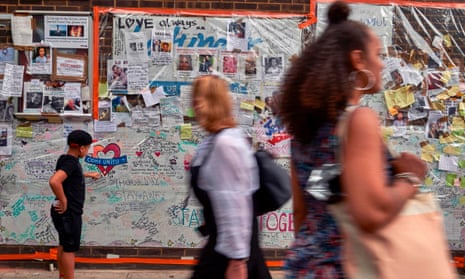 A boy looks at messages left by well-wishers in tribute to the victims of the Grenfell Tower fire.