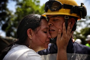 A woman hugs a man in a yellow hardhat