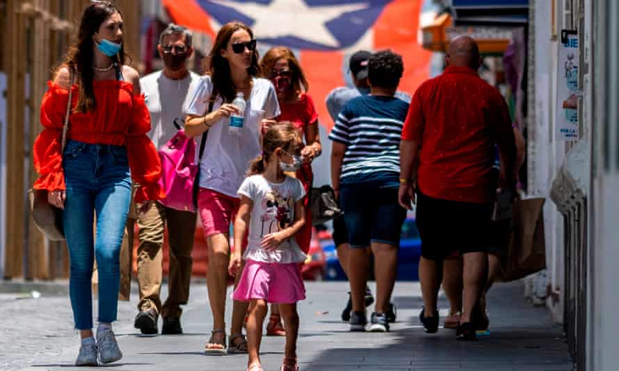 Tourists walk down a street in Old San Juan, Puerto Rico.