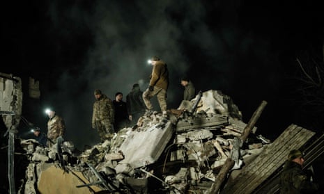Rescuers remove debris to search for survivors at a destroyed apartment building hit by a rocket during the night in downtown Kramatorsk.