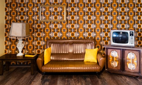A living room with 70-style wallpaper and furniture