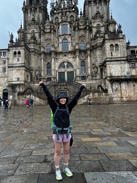 woman standing in front of cathedral with arms raised