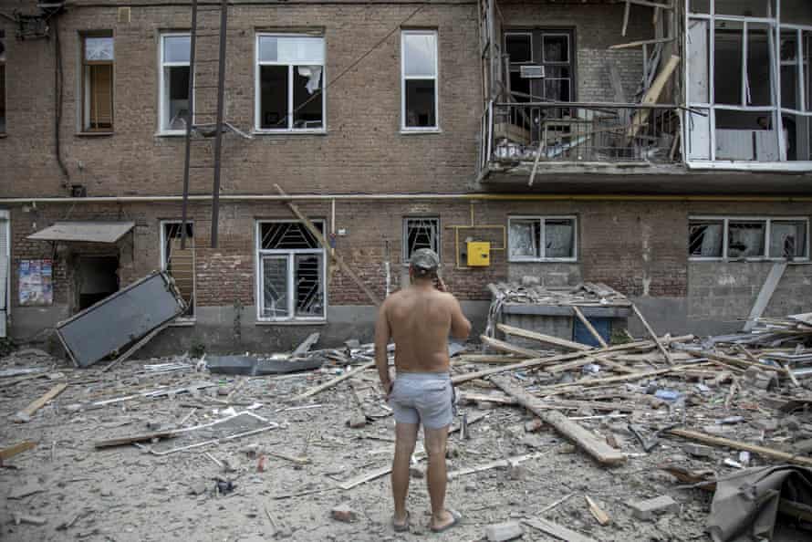 A local civilian stands in front of the destruction in Bakhmut.
