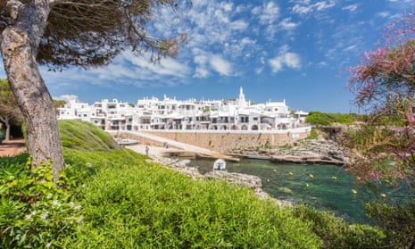 View across water towards the traditional whitewash village of Binibeca Vell, Menorca.