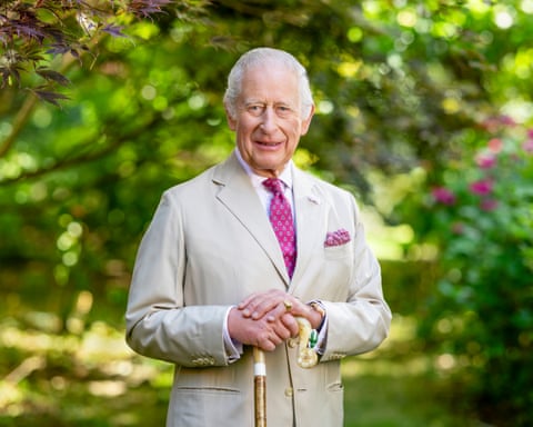 King Charles poses for portrait holding ornate walking stick
