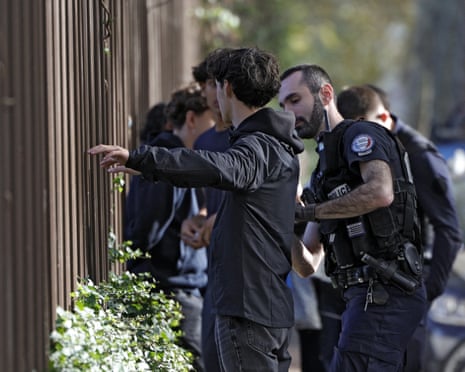 A protester is frisked by a police officer near the Michelet high school in Vanves, outside Paris.