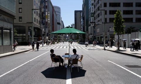 A couple rest under a parasol in the Ginza district of Tokyo