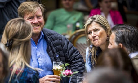 King Willem-Alexander and Queen Maxima drinking beer outside at a table 