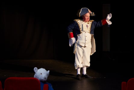 Patrick Hayes on stage dressed in historical military uniform, with White Bear looking at the camera over a seat in the stalls