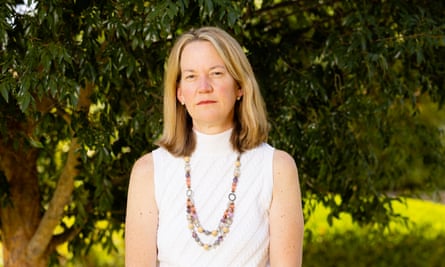 a woman stands in front of a tree