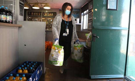 An NHS mental health worker collects food from a food bank set up in a pub in Northampton.