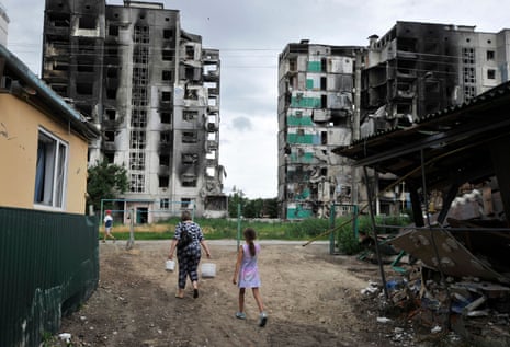 People walk near destroyed buildings in the town of Borodianka, near Kyiv.