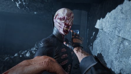 In Hellraiser, a bloodied hand reaches towards grotesque creature in a stone corridor