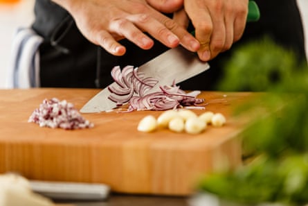 Chopping red onions on cutting board.