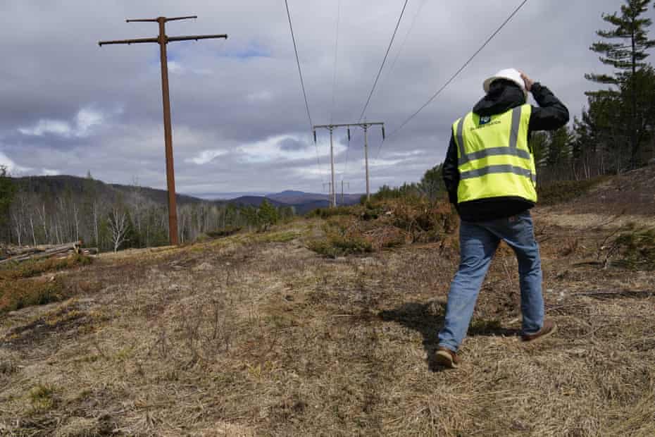 A worker inspects a Central Maine Power electricity corridor that has been widened to make way for new utility poles.