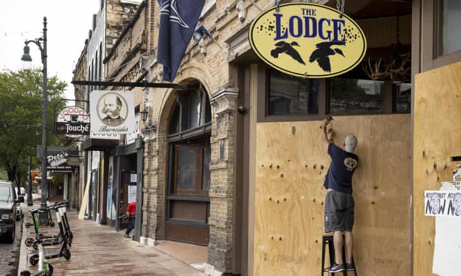 Matthew Gaskamp, general manager of The Lodge, boards up his bar on East 6th Street in Austin, Texas, Friday.