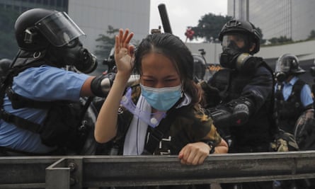 A protester reacts as she is tackled by riot police during a massive demonstration outside the legislative council in Hong Kong