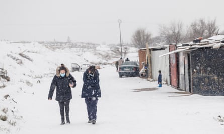 A nurse and a doctor walk through La Cañada Real after visiting a child suffering hypothermia in one of the houses